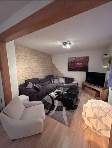 a living room with a couch and a tv at Ferienhaus Green Emotion in Suhl