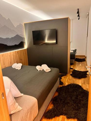 a bedroom with a bed with a tv on the wall at Royal Premium by Vucko Jahorina Serviced Apartments in Jahorina