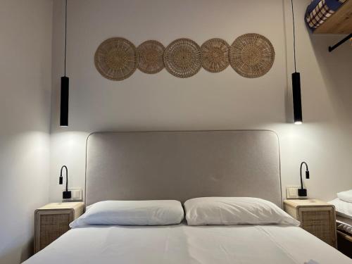 ein Schlafzimmer mit einem weißen Bett und zwei Nachttischen in der Unterkunft Beautiful renovated studio in Castelldefels