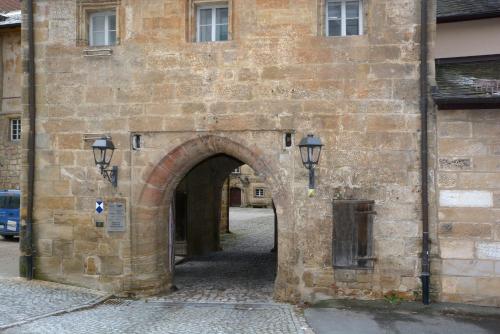 an archway in a brick building with a street at Schloss Thurnau in Thurnau