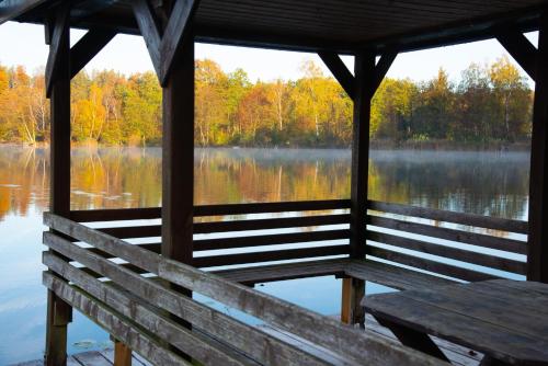a wooden bench in a gazebo overlooking a lake at Seehof direkt am See in Seeleiten