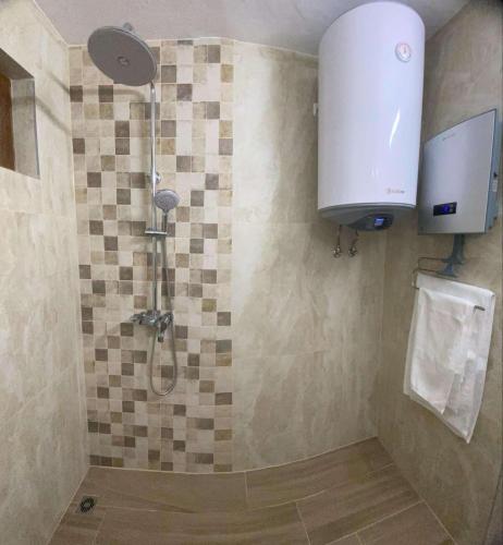 a bathroom with a shower with a toilet at Къща за гости Плами in Tryavna
