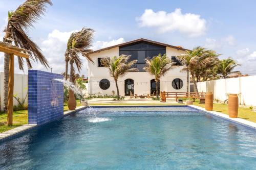 a house with a swimming pool in front of a house at Kitesurfing Paradise, Beautiful Beach House in Taíba