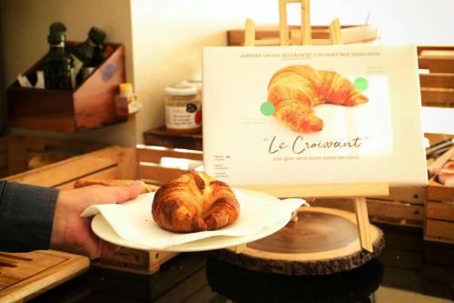 uma pessoa segurando um prato com um pão de croissants em Travelodge BCN Cornella Fira em Cornellà de Llobregat