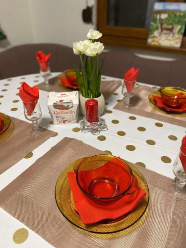 a table with red plates and red napkins and flowers at Къща за гости Плами in Tryavna