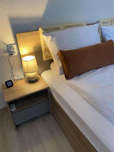 a bed with a night stand with a lamp on it at Къща за гости Плами in Tryavna