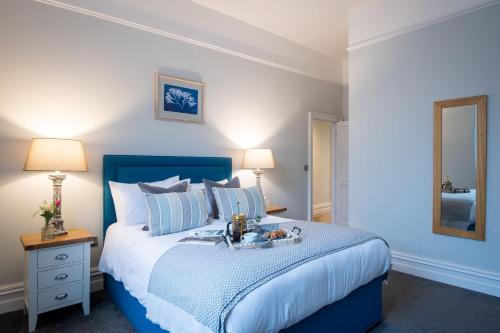 a bedroom with a blue bed with a tray of food on it at Sailors Rest in Dartmouth