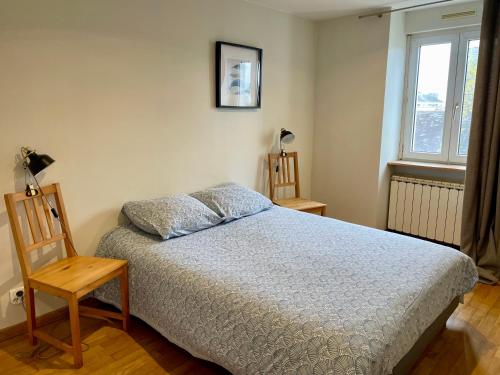 une chambre avec un lit, une chaise et une fenêtre dans l'établissement La Petite Escale, à Saint-Nazaire