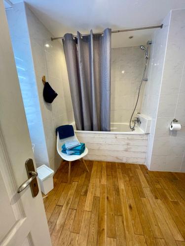 La salle de bains est pourvue d'une douche, de toilettes et d'une baignoire. dans l'établissement La Petite Escale, à Saint-Nazaire