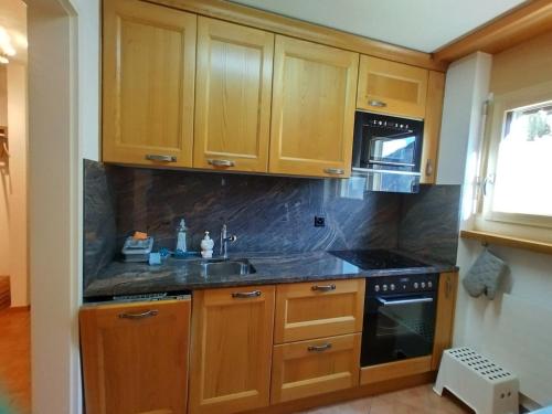 una cucina con mobili in legno e un lavello di Schwarzhorn 3 a Leukerbad