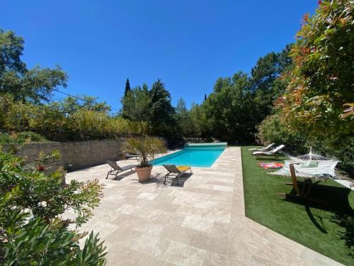 une arrière-cour avec une piscine et une terrasse avec des chaises dans l'établissement Villa Paradis - Saint Paul En Foret, à Saint-Paul-en-Forêt