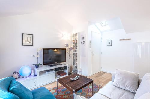 un salon avec un canapé et une télévision dans l'établissement Appartement Verdun - Welkeys, à Biarritz