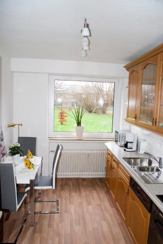 a kitchen with a sink and a table and a window at Aaltine 1 in Bad Bentheim