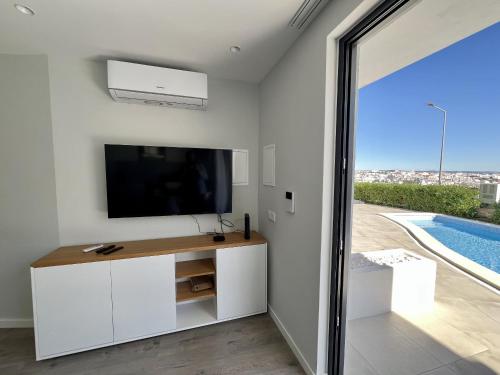 a living room with a television and a swimming pool at Albufeira Stylish 2 With Pool by Homing in Albufeira