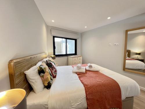 a bedroom with a large bed and a mirror at Albufeira Stylish 2 With Pool by Homing in Albufeira
