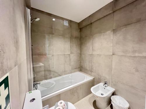 a bathroom with a tub and a toilet and a sink at Albufeira Stylish 2 With Pool by Homing in Albufeira