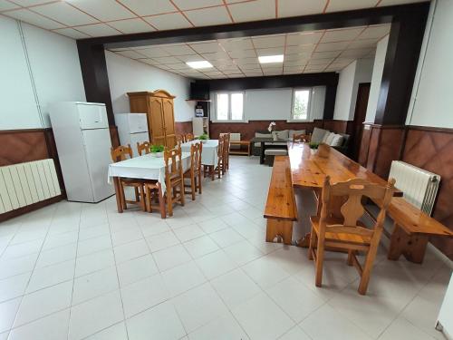 a dining room with wooden tables and chairs at Agerre Goikoa Agroturismo in Zarautz