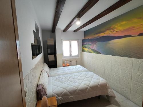 a bedroom with a bed and a painting on the wall at Agerre Goikoa Agroturismo in Zarautz
