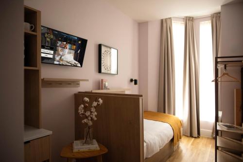 a bedroom with a bed and a vase of flowers on a table at Bob W London Holland Park in London