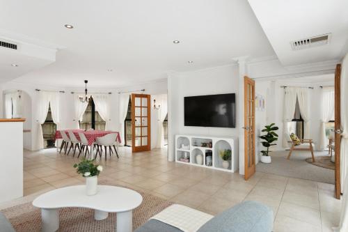 a living room with a tv on a wall at Entire Home Steps to Sorrento Beach in Perth