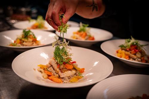 a person is preparing a plate of food on a table at Marienhöh - Hideaway & Spa in Langweiler