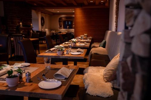 a restaurant with wooden tables and chairs and a tableasteryasteryasteryasteryasteryastery at Marienhöh - Hideaway & Spa in Langweiler