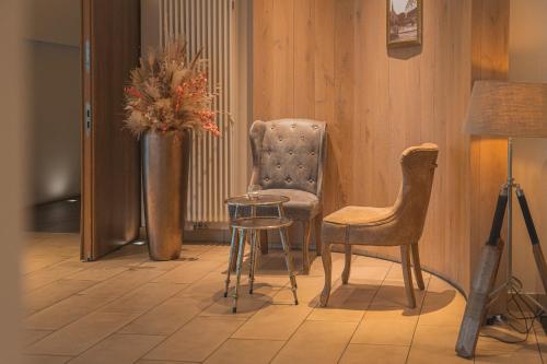a room with a table and a chair and a vase with flowers at Marienhöh - Hideaway & Spa in Langweiler
