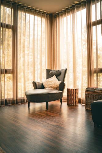 a living room with a chair in front of windows at Marienhöh - Hideaway & Spa in Langweiler