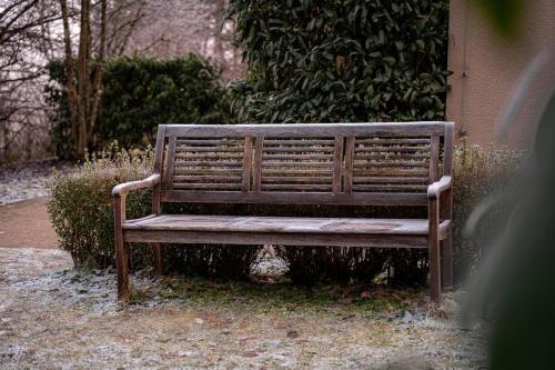 a wooden bench sitting next to a building at Marienhöh - Hideaway & Spa in Langweiler