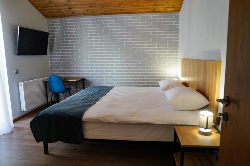 una camera da letto con un letto e un muro di mattoni di Peak Hotel Kazbegi a Kazbegi