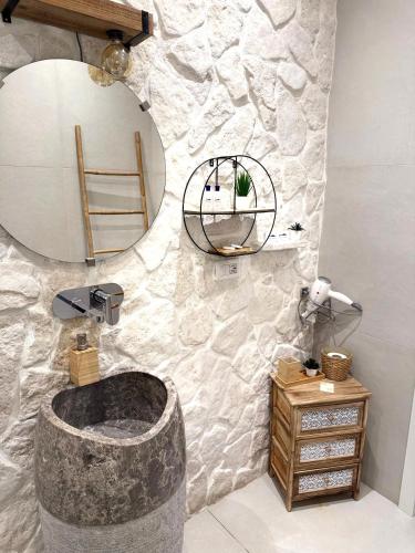 a bathroom with a large stone sink and a mirror at Pharus Miseni Suites and rooms in Bacoli