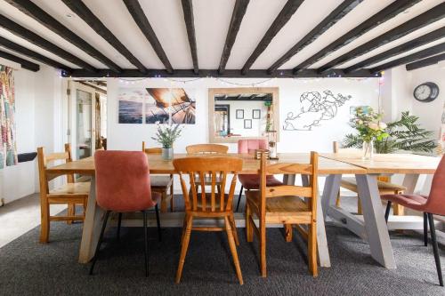 a dining room with a wooden table and chairs at Tranquil Luxe in Country Cottage in Bosham