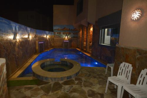 a swimming pool in a room with two white chairs at Tirazir House 2 in Mirleft