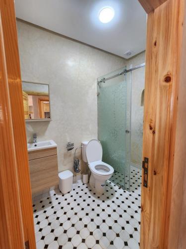 a bathroom with a toilet and a glass shower at Tirazir House 2 in Mirleft