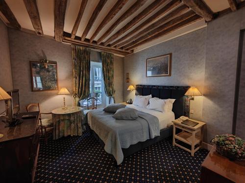 una camera da letto con un letto grande in una stanza di Le Relais Médicis a Parigi