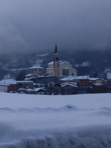 a building with a clock tower in the snow at Locanda San Giorgio in Sestola