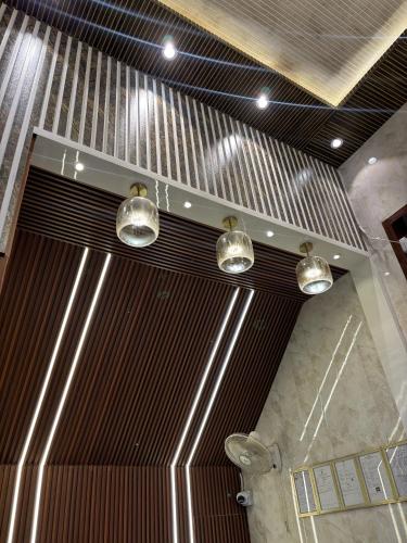 a bathroom with three lights hanging from the ceiling at Hotel Ramay Palace in Ayodhya