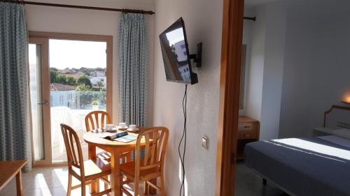 a room with a table and chairs and a bedroom at Mar y Paz by Youroom in Can Picafort