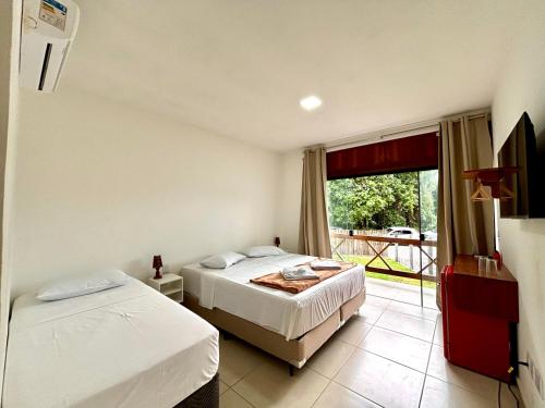 En eller flere senge i et værelse på POUSADA MEL DO CACAU