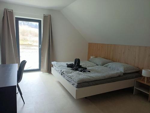 a bedroom with a bed with a pair of shoes on it at Wellness Chalupy LETOKRUHY in Jeseník