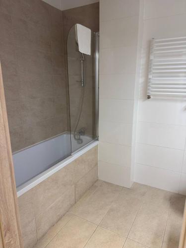 a bathroom with a shower with a tub and a sink at Zlatarooms in Warsaw