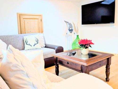a living room with a couch and a coffee table at Neu! Moderner bayrischer Flair vor Pilatushaus in Oberammergau