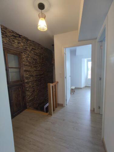 an empty room with a brick wall and a door at Casa Sáner in Rábade