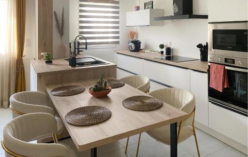 a kitchen with a wooden table and chairs in a kitchen at Jolie Maison in Pornic