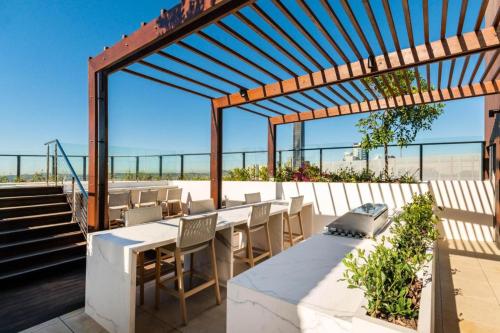 an outdoor patio with tables and chairs and a pergola at Luxury Peppers Infinity Pool Stylish with 2BD & 1C Park in Brisbane