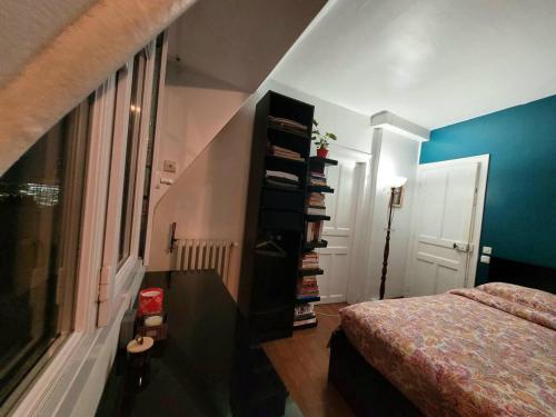 une chambre avec un lit et une étagère dans l'établissement Loft très calme tout confort proche Parc des Expos de Versailles vue Tour Eiffel, à Paris