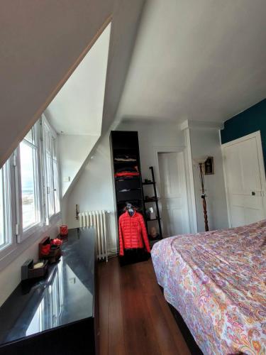 une chambre mansardée avec un lit et une fenêtre dans l'établissement Loft très calme tout confort proche Parc des Expos de Versailles vue Tour Eiffel, à Paris