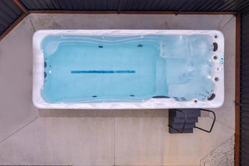 a bath tub with blue water in a room at Luxury Hunter Valley Acreage - Heated SwimSpa - Mountain Views - Pool Table - Fire Pitt in Millfield