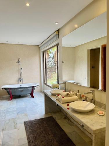 a bathroom with two sinks and a bath tub at Hala Luxury Domain in Marrakesh