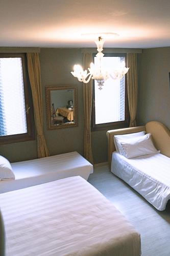 a bedroom with two beds and a chandelier at H O T E L S A N G A L L O l in Venice